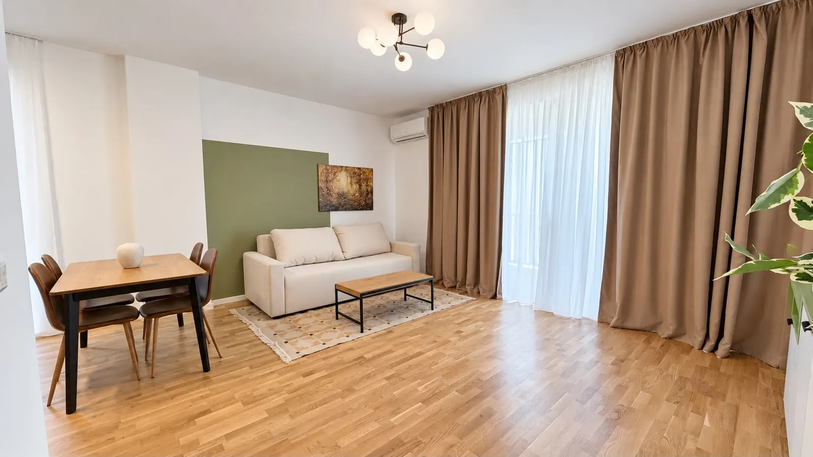 Living room with a cream sofa, a green wall and a table for four, at Torontal, Timișoara