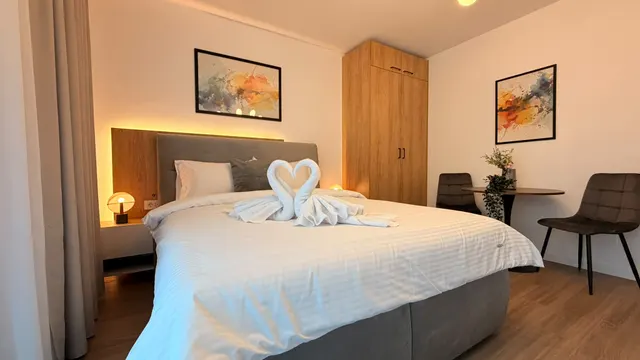 Bed made up for guests, with towels folded into swans, at Icon Studio, București