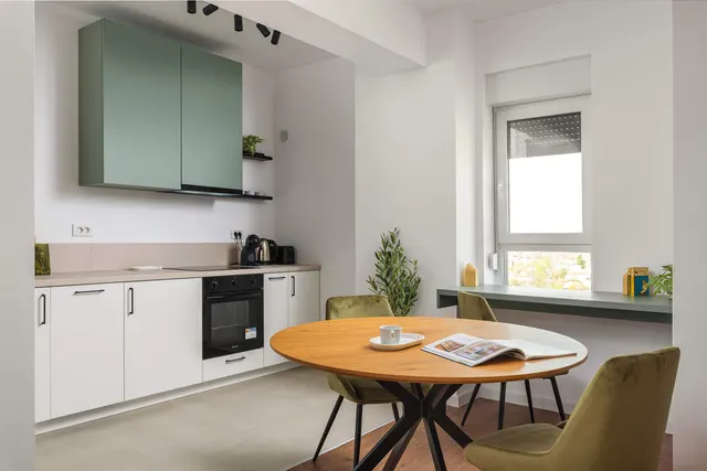 Kitchen with green cabinets, a round wooden table and green chairs, at City of Mara, Timișoara