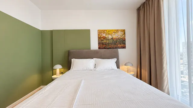 Bedroom with a green wall, bedside lamps and an autumn painting, at Torontal, Timișoara