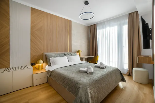 Bedroom with a double bed, a wood-panelled wall and long curtains, at Coresi, Brașov