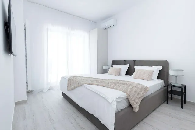 Bedroom with a double bed and white sheer curtains, at Casa del Mar, Mamaia Nord