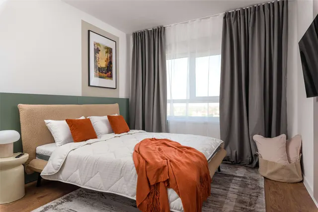 Bed with an upholstered headboard and a painting above it, at City of Mara, Timișoara