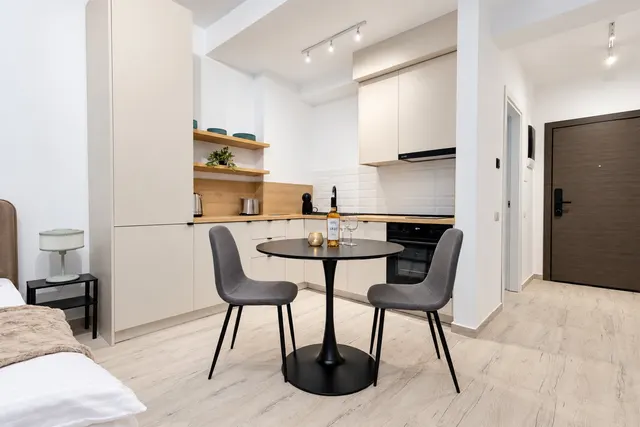 Kitchenette with a round table for two in a studio, at Casa del Mar, Mamaia Nord