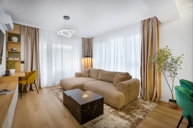 Living room with a beige sofa, a black coffee table and a potted olive tree, at Coresi, Brașov