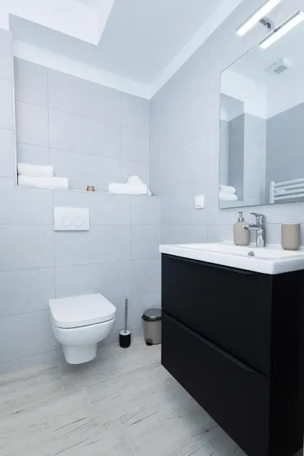 Modern bathroom with a black vanity unit and a mirror, at Casa del Mar, Mamaia Nord
